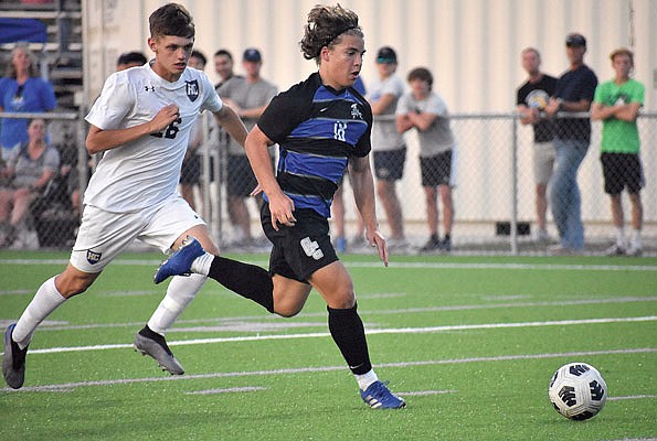 Mo Yanis of Capital City drives the ball towards the goal as Trent Wolken of Helias defends during Monday night's game at Capital City High School.