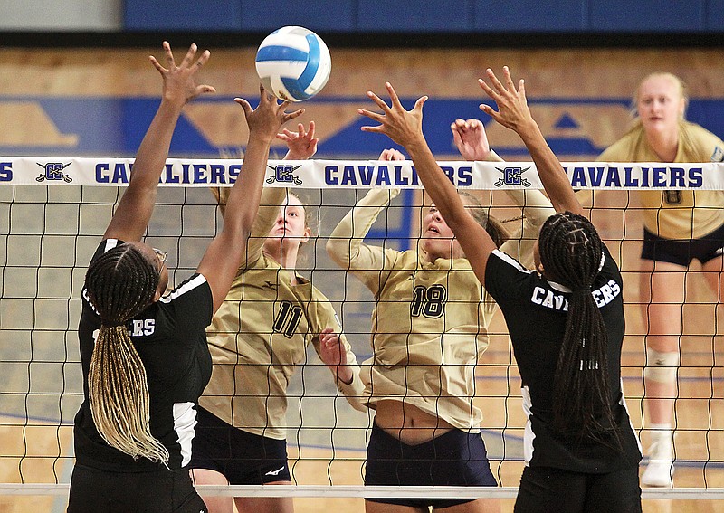 Capital CIty's Michelyn Appiah (far left) and Kiara Strayhorn (far right) reach to try and block a spike by Helias' Josie Morasch (11) as teammate Summer Hake (18) also jumps at the net during Monday night's match at Capital City High School.