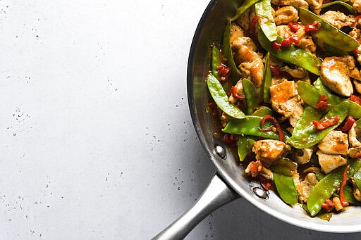 This image released by Milk Street shows a recipe for stir-fried chicken and snow peas. This recipe, with just six ingredients, was inspired by the popular Malaysian dish ayam paprik.  (Milk Street via AP)