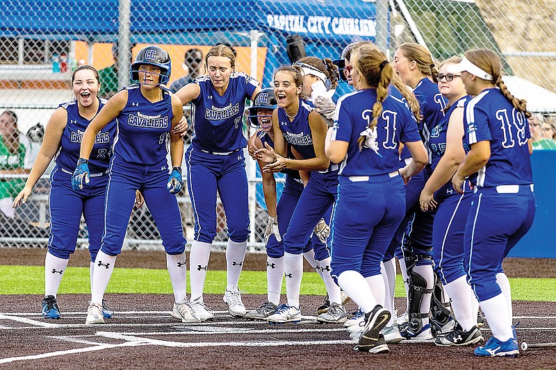 Capital City softball players gather around home plate to wait for Camryn Sharp after she hit a home run during last week's game against Blair Oaks at Capital City High School.