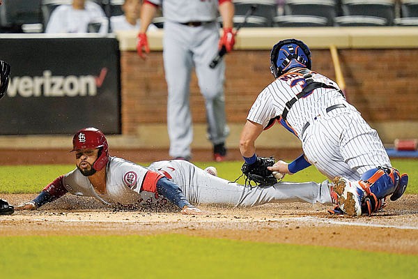 Edmundo Sosa of the Cardinals slides past Mets catcher James McCann to score on a Harrison Bader single during Wednesday night's game in New York.