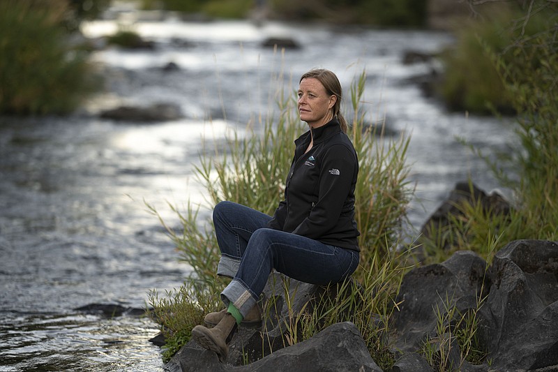 Kate Fitzpatrick, the executive director of the Deschutes River Conservancy, poses for a press photo along the banks of the middle Deschutes River on Tuesday, Aug. 31, 2021, in Bend, Ore. "We're trying to figure out ways for water to move around more flexibly," she said. "If we can find those win-win solutions, I believe that the Deschutes can be a model for the West as the West faces increasing drought and scarcity and population growth." (AP Photo/Nathan Howard)