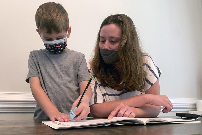<p>AP Photo/Sarah Blake Morgan</p><p>Emily Goss goes over school work at the kitchen table with her five-year-old son inside their Monroe, N.C., home on Monday, Sept. 13, 2021. The Goss’ have decided to homeschool Berkeley after the Union County school district chose not to implement a mask mandate for children.</p>