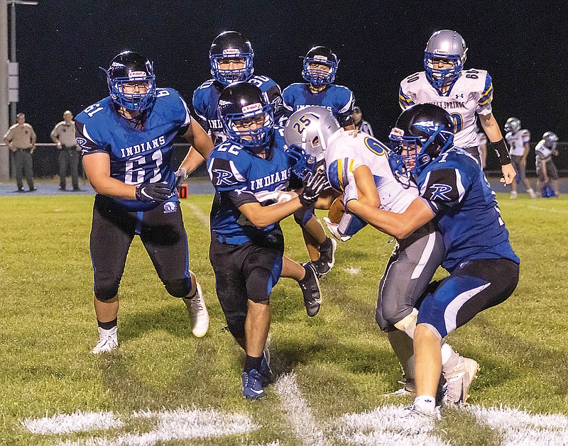 Russellville's Drake Adams (left) and Alex Oligschlaeger (right) wrap up Sweet Springs ball carrier Cole Lovercamp during last Friday's game at Russellville.