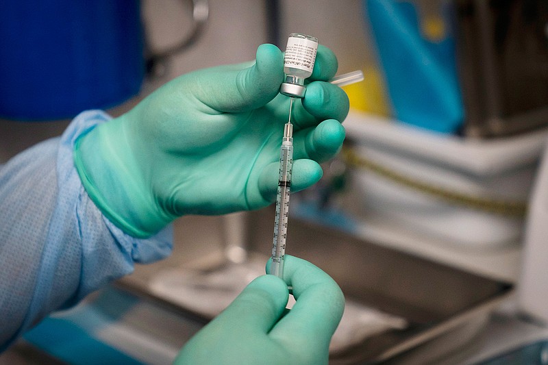 In this Thursday, Aug. 26, 2021 file photo, a syringe is prepared with the Pfizer COVID-19 vaccine at a mobile vaccine clinic in Santa Ana, Calif. New U.S. studies released on Friday, Sept. 10, 2021 show COVID-19 vaccines remain highly effective, especially against hospitalizations and death, even against the extra-contagious delta variant. (AP Photo/Jae C. Hong)