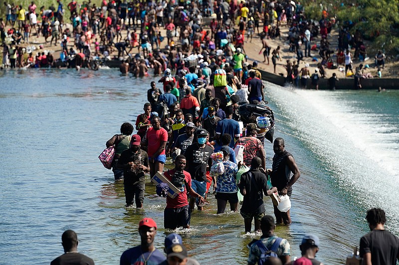 Haitian migrants use a dam to cross to and from the United States from Mexico, Friday, Sept. 17, 2021, in Del Rio, Texas. Thousands of Haitian migrants have assembled under and around a bridge in Del Rio presenting the Biden administration with a fresh and immediate challenge as it tries to manage large numbers of asylum-seekers who have been reaching U.S. soil. (AP Photo/Eric Gay)