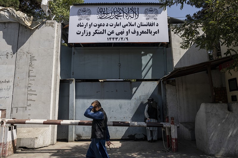 An Afghan man walks past the former Women's Affairs Ministry building in Kabul, Afghanistan, Saturday, Sept. 18, 2021. Afghanistan's new Taliban rulers set up a ministry for the "propagation of virtue and the prevention of vice" in the building that once housed the Women's Affairs Ministry, escorting out World Bank staffers Saturday as part of the forced move. (AP Photo/Bernat Armangue)