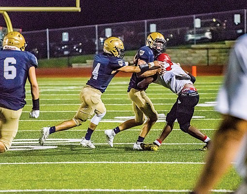 Helias teammates Gage Wilde (4) and Beau Bondurant team up to tackle Granite City quarterback Kayshawn White for a big loss Friday night at Ray Hentges Stadium.