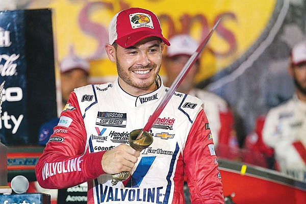 Kyle Larson examines the sword presented to him after winning Saturday night's NASCAR Cup Series race at Bristol Motor Speedway in Bristol, Tenn.
