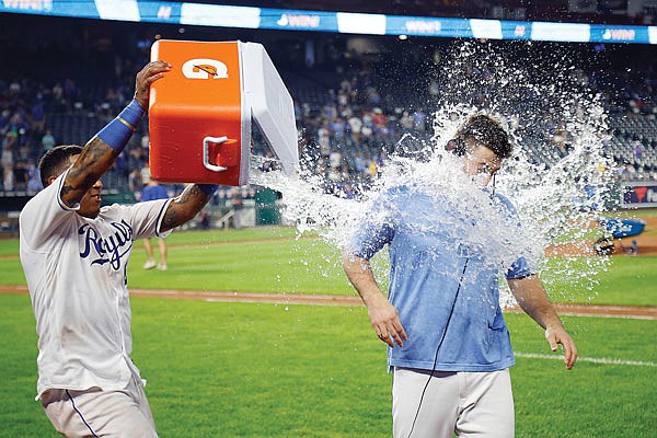 Salvador Perez douses Royals starting pitcher Kris Bubic as he is interviewed following Saturday night's 8-1 win against the Mariners at Kauffman Stadium.