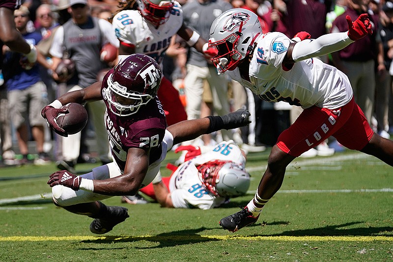 Texas A&M running back Isaiah Spiller (28) dives over the goal for a touchdown against New Mexico defensive back Ronald Wilson (14) during the first half of an NCAA college football game on Saturday, Sept. 18, 2021, in College Station, Texas. (AP Photo/Sam Craft)