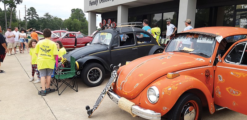 Volkswagen Beetles, such as this orange one rescued from a farmer's field by Dustin and Susan Moore, are finding their way into the care of classic car fans. Such cars were on display at Saturday's Beetles on the Boulevard.