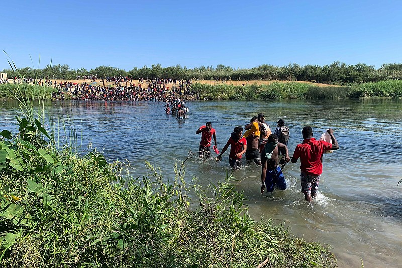 Migrants find an alternate place to cross from Mexico to the United States after access to a dam was closed, Sunday, Sept. 19, 2021, in Ciudad Acuña, Mexico. U.S. officials said that within the next few days, they plan to ramp up expulsion flights for some of the thousands of Haitian migrants who have gathered in the Texas city from across the border in Mexico. (AP Photo/Sarah Blake Morgan)