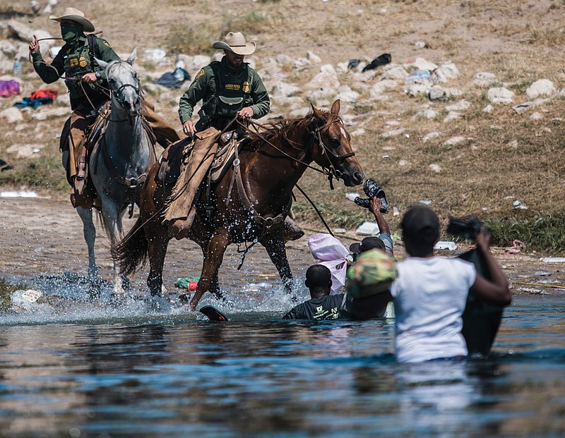 U.S. Customs and Border Protection mounted officers attempt to contain migrants Sunday as they cross the Rio Grande from Ciudad Acua, Mexico, into Del Rio, Texas. Thousands of Haitian migrants have been arriving as authorities attempt to close the border to stop the flow of migrants. 