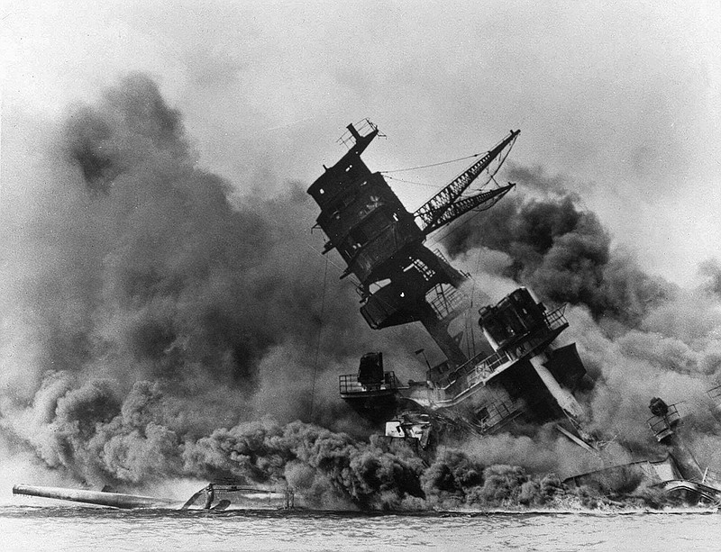 In this Dec. 7, 1941, file photo, smoke rises from the battleship USS Arizona as it sinks during a Japanese surprise attack on Pearl Harbor, Hawaii. The declassified U.S. military documents show the ashes of seven executed war criminals, including wartime Prime Minister Hideki Tojo, were scattered at sea off Yokohama from  a U.S. army plane. (AP Photo, File)