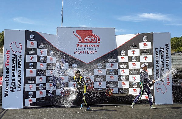 Colton Herta (center) celebrates his IndyCar victory Sunday at Laguna Seca with runner-up Alex Palou (left) and Romain Grosjean in Monterey, Calif.