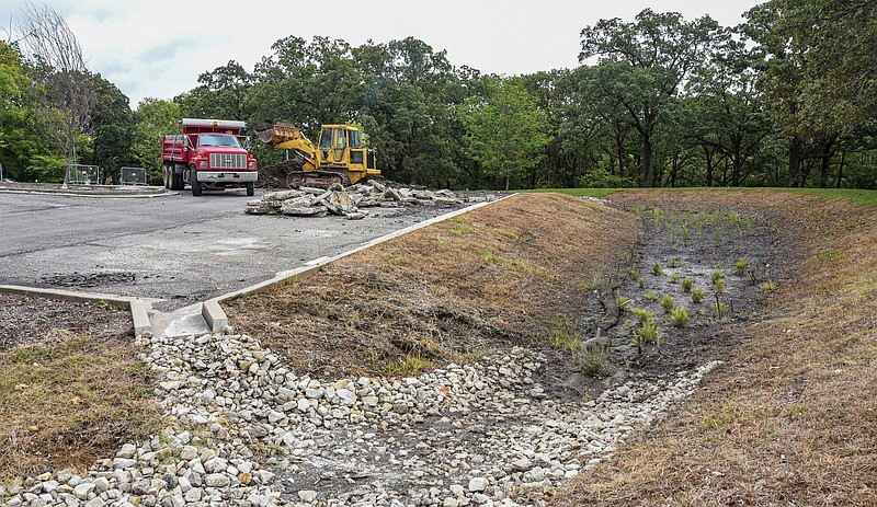 <p>Julie Smith/News Tribune</p><p>An operator from the Jefferson City Parks, Recreation and Forestry Department takes up the surface in the lower portion of the parking lot Tuesday at McClung Park to make room for more green space, which will run into the bio swell shown in foreground. To make room for the natural surface, approximately 30 parking spaces will be lost.</p>
