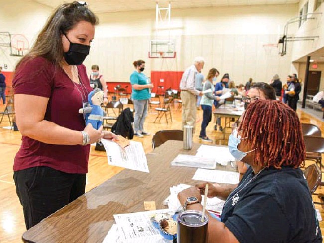 Playing the part of Glen Guten, a parent dropping off and picking up his child from daycare, Amy VanOverschelde takes part in the Rethink Poverty event Tuesday, Sept. 21, 2021, at First Baptist Church Activities Center in Jefferson City.