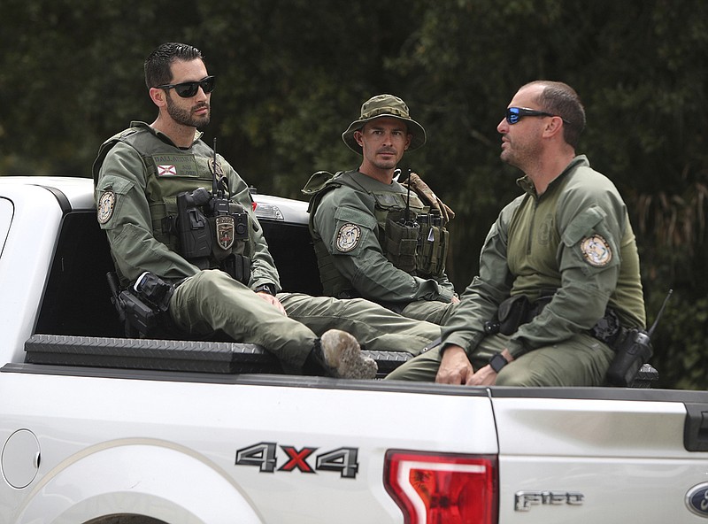 Law enforcement officers enter the T. Mabry Carlton Reserve in North Port, Fla., as they search for Brian Laundrie, Saturday, Sept. 18, 2021. Laundrie was traveling on a cross-country road trip with Gabby Petito, 22, who went missing in August. Petito's body was apparently discovered over the weekend at Grand Teton National Park. (Matt Houston/Sarasota Herald-Tribune via AP)