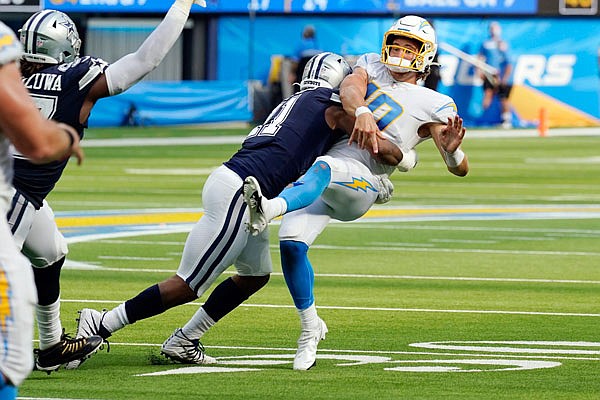 Chargers quarterback Justin Herbert is hit by Cowboys linebacker Micah Parsons as he throws during last Sunday's game in Inglewood, Calif.