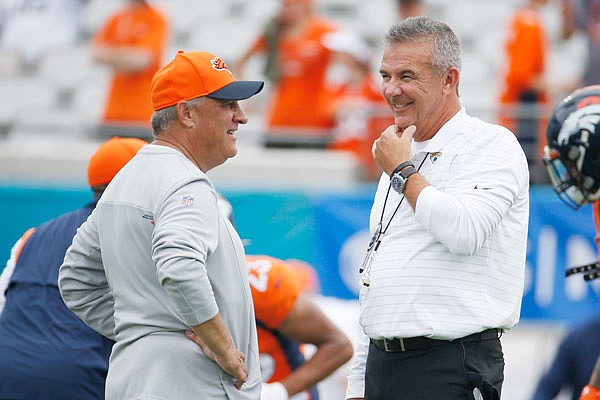 Broncos head coach Vic Fangio (left) and Jaguars head coach Urban Meyer talk before last Sunday's game in Jacksonville, Fla.