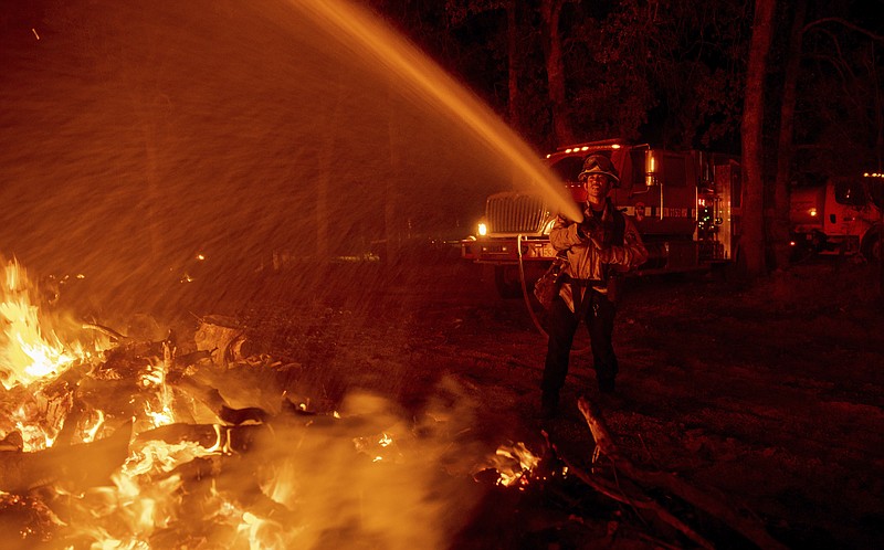 Firefighter Ron Burias battles the Fawn Fire as it spreads north of Redding, Calif. in Shasta County, on Thursday, Sept. 23, 2021. (AP Photo/Ethan Swope)