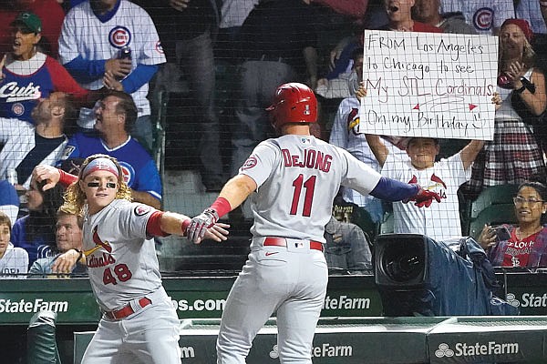 Paul DeJong celebrates his home run with Cardinals teammate Harrison Bade, as a Cardinals fan gets a birthday wish during the third inning of Friday night's second game of a doubleheader against the Cubs in Chicago.