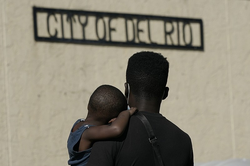 <p>AP</p><p>A Haitian migrant carries a boy Friday while waiting to board a bus provided by a humanitarian group after being released from U.S. Customs and Border Protection custody in Del Rio, Texas. The “amistad,” or friendship, that Del Rio, Texas, and Ciudad Acuña, Mexico, celebrate with a festival each year has been important in helping them deal with the challenges from a migrant camp that shut down the border bridge between the two communities for more than a week. Federal officials announced the border crossing would reopen to passenger traffic late Saturday afternoon and to cargo traffic on Monday. (AP Photo/Julio Cortez)</p>