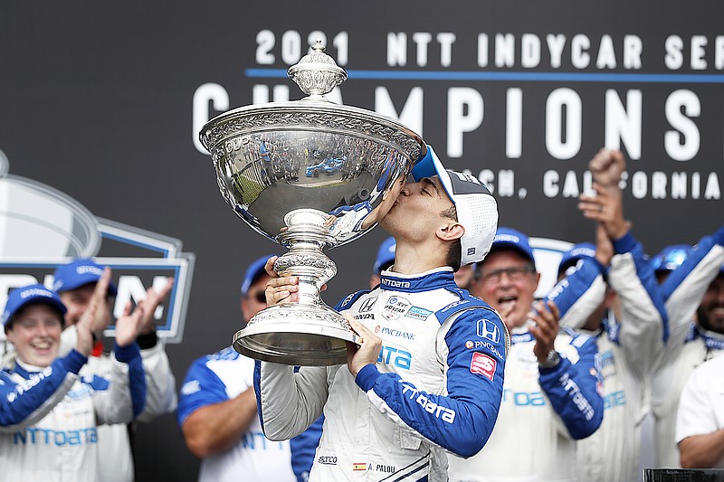 NTT IndyCar Series winner Alex Palou celebrates with the trophy after taking fourth place in Sunday's IndyCar race at the Grand Prix of Long Beach in Long Beach, Calif.