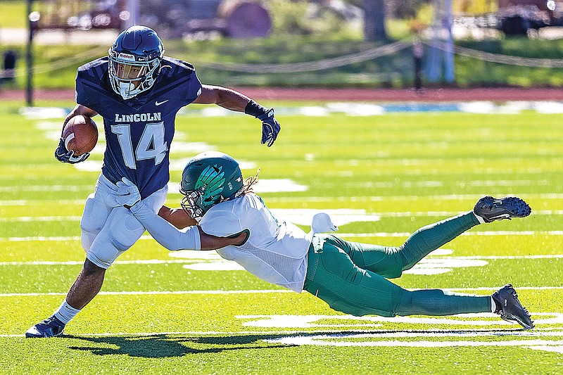 Lincoln wide receiver Winston Ausmer attempts to break free from a tackle by Northeastern State defensive back Bryce Brown during Saturday afternoon's MIAA game at Dwight T. Reed Stadium.