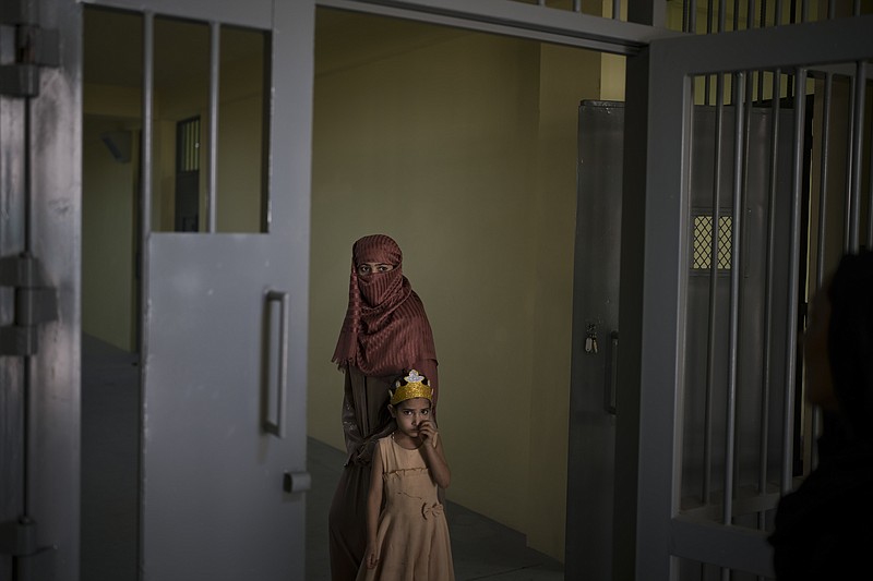 Razia and her 6-year-old daughter Alia, stand inside the women's section of the Pul-e-Charkhi prison in Kabul, Afghanistan, Thursday, Sept. 23, 2021. When the Taliban took control of a northern Afghan city of Pul-e-Kumri the operator of the only women's shelter ran away, abandoning 20 women in it. When the Taliban arrived at the shelter the women were given two choices: Return to their abusive families, or go with the Taliban, With nowhere to put the women, the Taliban took them to the abandoned women's section of Afghanistan's notorious Pul-e-Charkhi prison. (AP Photo/Felipe Dana)