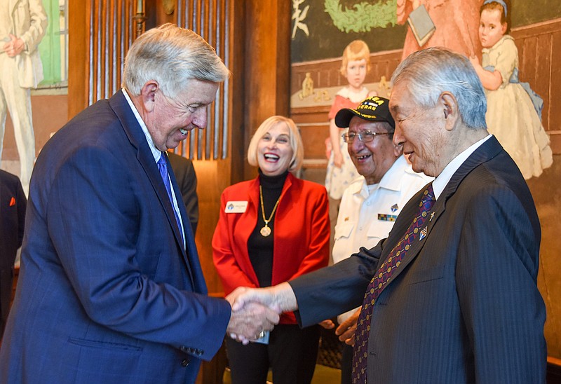 <p>Julie Smith/News Tribune</p><p>Gov. Mike Parson, left, greets Yong L. Kim, as he enters the Governor’s Office on Tuesday for a brief ceremony. In the background are Debra Shultz, middle left, and Paul Rojas, a Korean War veteran who served with the U.S. Navy.</p>