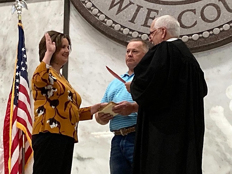 Lori Caraway is sworn in as Bowie County District Clerk by 202nd District Judge John Tidwell in the courthouse lobby Thursday morning. Caraway swore to faithfully discharge her duties with a hand on her mother's first Bible as her husband, Joe Caraway, stood by.
