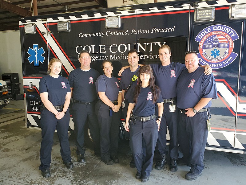 Members of the Cole County EMS show the t-shirts they'll be wearing during October to help raise awareness about breast cancer, which is the most common cancer diagnosed in women in the United States. Pictured from left to right are: paramedic Natalie Schlieder, Chief Eric Hoy, Battalion Chief Gretchen Bodley, paramedic Sam Gibson, EMT Austin Luebbert and paramedic Mike Shirts. Pictured in front is EMT Jessica Wieberg. (Jeff Haldiman photo) 
