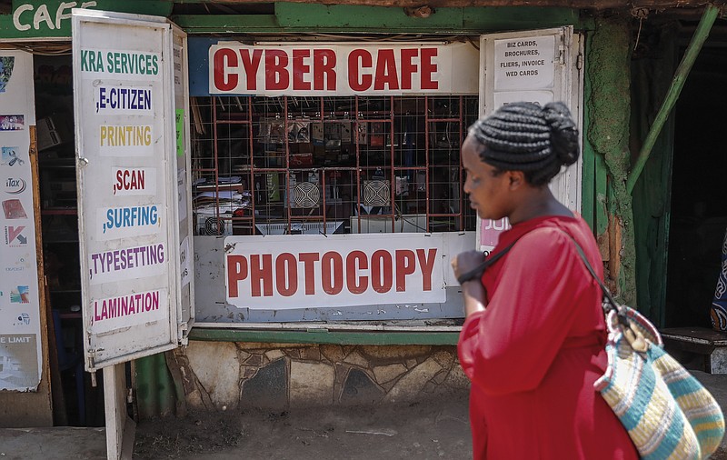 A pedestrian walks past an internet cafe in the low-income Kibera neighborhood of Nairobi, Kenya Wednesday, Sept. 29, 2021. Instead of serving Africa's internet development, millions of internet addresses reserved for Africa have been waylaid, some fraudulently, including in insider machinations linked to a former top employee of the nonprofit that assigns the continent's addresses. (AP Photo/Brian Inganga)