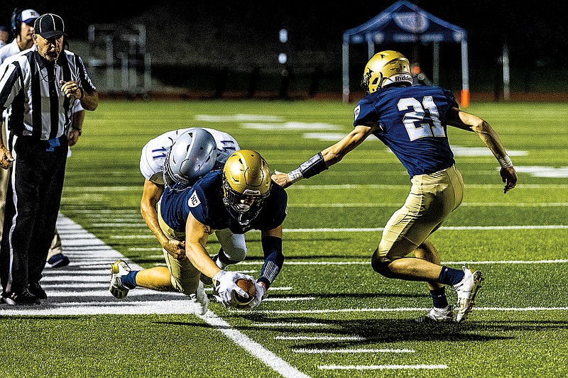 Trey Bexten of Helias is brought down by Capital City's Colton Sheehan during Friday night's game at Ray Hentges Stadium.