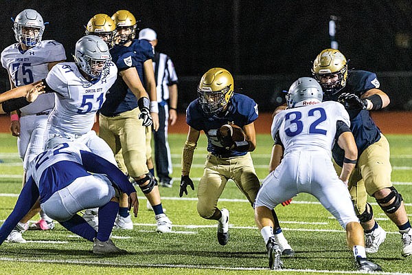 Helias running back Ryan Klahr tries to work his way through the Capital City defense during Friday night's game at Ray Hentges Stadium.