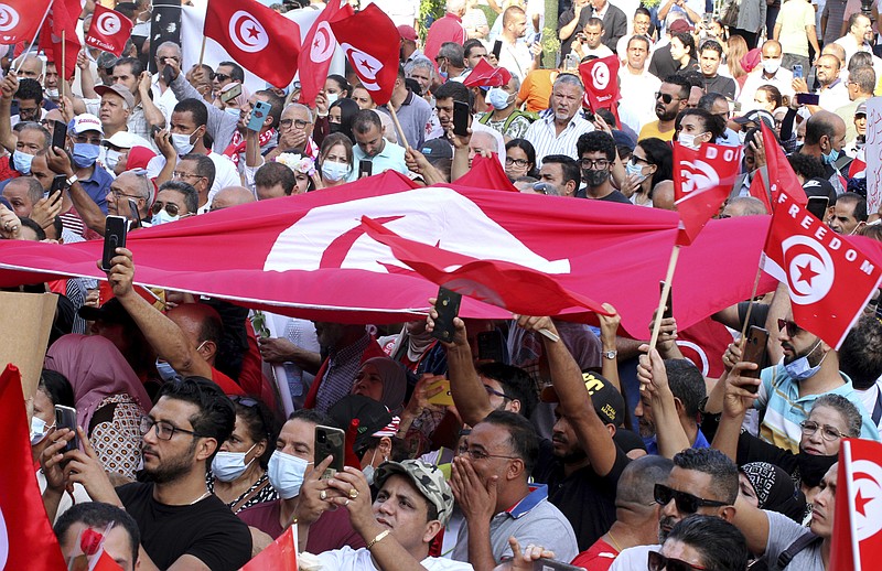 Tunisians demonstrate in support of Tunisian President Kais Saied in Tunis, Tunisia, Sunday, Oct. 3, 2021. President Saied froze the country's parliament and sacked the prime minister on July 25, 2021. (AP Photo/Hassene Dridi)