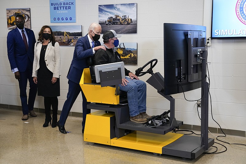 President Joe Biden tours the International Union Of Operating Engineers Local 324 training facility, Tuesday, Oct. 5, 2021, in Howell, Mich. Michigan Lt. Gov. Garlin Gilchrist, left, and Michigan Gov. Gretchen Whitmer second from left, look on. (AP Photo/Evan Vucci)