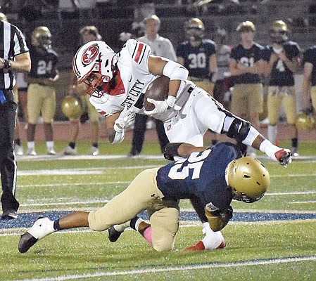 Zane Wings of Jefferson City is brought down by Ryan Klahr of Helias during Friday night's game at Ray Hentges Stadium.