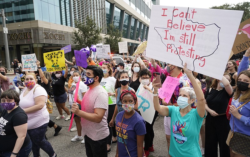 FILE - In this Oct. 2, 2021 file photo people participate in the Houston Women's March against Texas abortion ban walk from Discovery Green to City Hall in Houston.  A federal appeals court is temporarily allowing the nation’s toughest abortion law to resume in Texas. The 5th U.S. Circuit Court of Appeals handed down the order Friday, Oct. 8.  (Melissa Phillip/Houston Chronicle via AP, File)