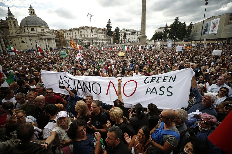 People gather in Piazza del Popolo square during a protest, in Rome, Saturday, Oct. 9, 2021. Thousands of demonstrators protested Saturday in Rome against the COVID-19 health pass that Italian workers, both the public and private sectors, must display to access their workplaces from Oct. 15 under a government decree. (Cecilia Fabiano/LaPresse via AP)
