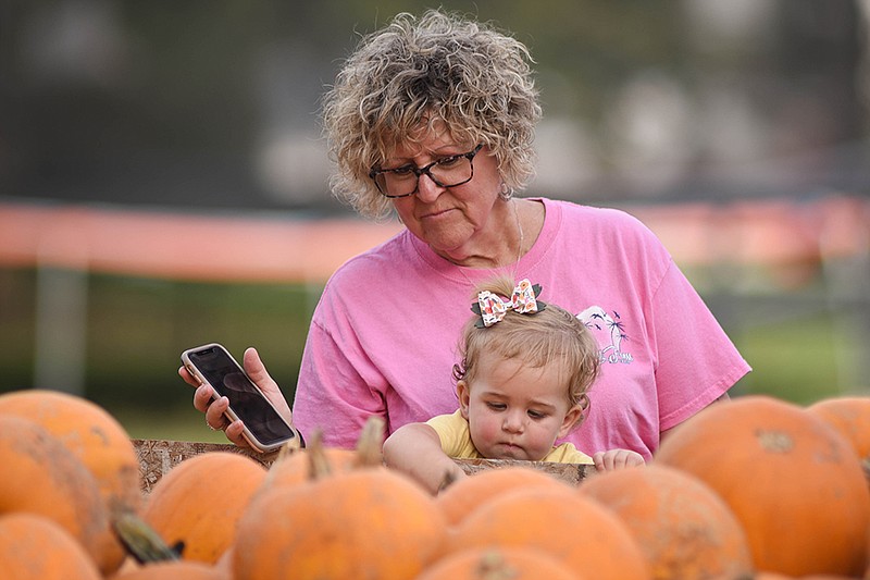 <p>India Garrish/For the Fulton Sun</p><p>Becky McCoy, of Harrisburg, holds her granddaughter, Camille Smith, 15 months, of Ashland, Saturday at the Hartsburg Pumpkin Festival. This was Camille’s first time at the Pumpkin Festival, and she was fascinated with the color of the pumpkins, McCoy said.</p>
