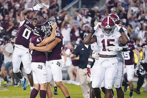 Texas A&M's Seth Small (47) celebrates with Nik Constantinou (95) and Ainias Smith (0) after his game-winning field goal Saturday night as Alabama linebackers Dallas Turner (15) and Will Anderson Jr. leave the field in College Station, Texas.