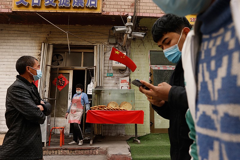 <p>AP</p><p>A vendor selling Uyghur’s naan bread waits for customers on March 20 on a street in Shule county in northwestern China’s Xinjiang Uyghur Autonomous Region. Four years after Beijing’s brutal crackdown on largely Muslim minorities native to Xinjiang, Chinese authorities are dialing back the region’s high-tech police state and stepping up tourism. But even as a sense of normality returns, fear remains, hidden but pervasive.</p>