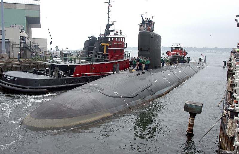 FILE - In this Friday, July 30, 2004 file photo, the U.S.S. Virginia returns to the Electric Boat Shipyard in Groton Conn., after its first sea trials. A Navy nuclear engineer with access to military secrets has been charged with trying to pass information about the design of American nuclear-powered submarines to someone he thought was a representative of a foreign government but who turned out to be an undercover FBI agent, the Justice Department said Sunday, Oct. 10, 2021. (AP Photo/Jack Sauer, File)