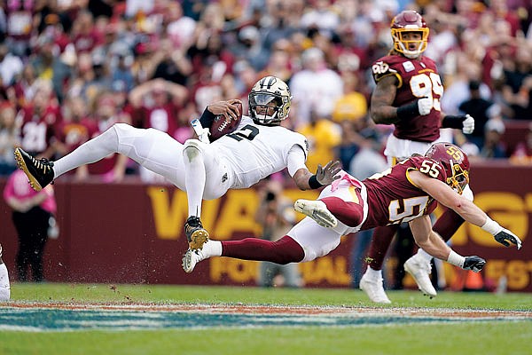 Saints quarterback Jameis Winston is flipped over by Washington Football Team linebacker Cole Holcomb in the second half of Sunday's game in Landover, Md.