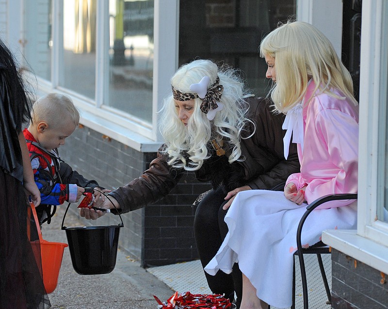 High Street Trick or Treat held on Halloween 2020. Cara Alexander Stark (right) and Della Stark of the Cork & Board store hand out candy to those passing by in front of the store. Shaun Zimmerman / News Tribune photo