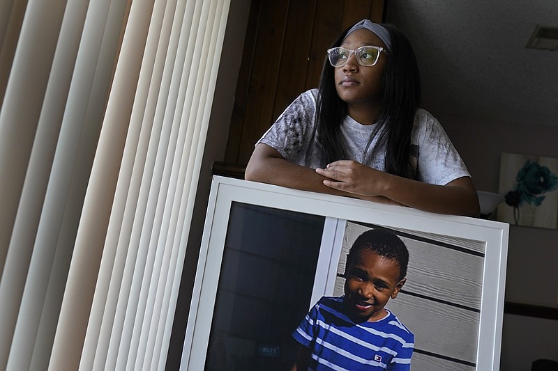 <p>AP</p><p>Charron Powell stands with a photo of her son, LeGend Talieferro, Sunday at her home in Raytown. LeGend was 4 years old when he was fatally shot June 29, 2020, while he was sleeping in an apartment staying with his father.</p>