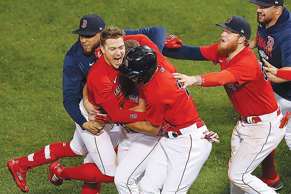Enrique Hernandez celebrates with Red Sox teammates after hitting a sacrifice fly to win Monday night's game against the Rays in Boston.